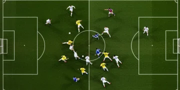 Aerial view of soccer players executing a defensive transition to prevent a counter-attack on a green field.
