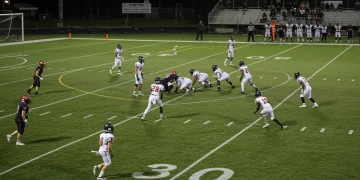 Dynamic football match with players executing fluid positional rotations in attack