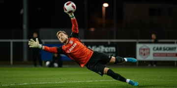 Goalkeeper in action, making a crucial save during a soccer match, representing modern US goalkeeper demands.