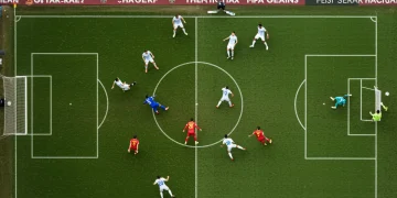Soccer players executing a tactical corner kick routine on a green field